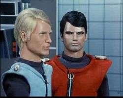 Video clip from "Attack on Cloudbase" demonstrating the difficulties of inducing realistic motion in the puppet characters of "Captain Scarlet and the Mysterons". Whenever a character is required to move, the camera shifts to a close-up angle to conceal the hand of a puppeteer pushing the puppet forward. The shot is interrupted when Captains Scarlet and Blue walk into a room through an automatic door as it was impossible to film the action in a single motion.