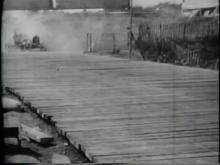 A car drives off a wooden plank road, before reversing back onto the track and continuing