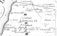 A black and white map with Old English style type showing an area by the side of a large river on the left, with many small houses and churches
