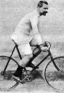 A man posing while sitting on a bike.