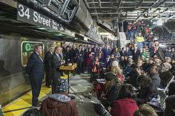 People speaking at a ceremonial speech at the 34th Street station on December 21, 2013