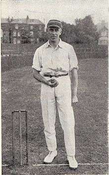 A man in a cricket cap holding a ball