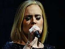 A photograph of Adele performing live.