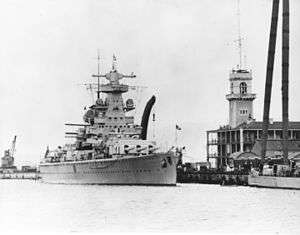 Black-and-white photograph of heavy cruiser Admiral Scheer moored at dock.