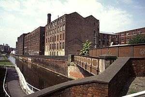Tall brick buildings by a canal