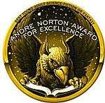 A gryphon or eagle reading a book, partly overwritten by the caption "Andre Norton Award for Excellence", in a circular seal with "Best Young Adult Science Fiction or Fantasy" written around the top edge