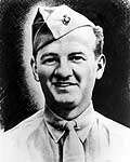 Head of a half-smiling white man wearing a shirt and tie and a garrison cap tilted over his right ear.