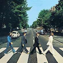 The cover of Abbey Road has no printed words. It is a photo of the Beatles, in side view, crossing the street in single file.