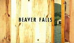 Beaver Falls written in black letters against a wooden door, slightly ajar, showing a lake.