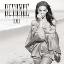 Grayscale portrait of a woman who is standing next to a beach. She is wearing a metallic short dress. She crosses her left arm across her body while the other arm rests against her face. Next to her image, appear the words "Beyoncé" and "Halo" in silver capital letters.