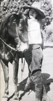 Portrait of Billie Maxwell posed with a horse