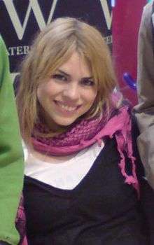 A woman wearing a purple scarf and smiling