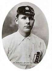 A young man wearing an old-fashioned white football shirt and a dark cap with the date 1907 on it. On his breast pocket is the England football Three Lions logo.