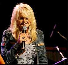A woman with blonde hair singing