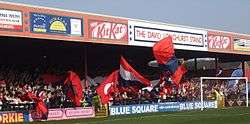 One of the stands of the Bootham Crescent association football ground, with supporters waving flags
