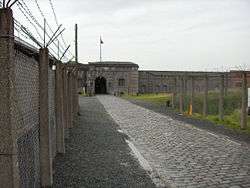 View of a fort in the distance with a chain-link fence to the left