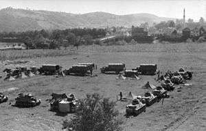 a black and white photograph of German armoured vehicles and tents in a square formation in open country