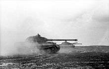 Three tanks moving across a field