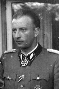 A man in semi profile wearing a military uniform and a neck order in the shape of a cross.