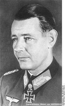 Black-and-white portrait of a man in semi profile wearing a military uniform with an Iron Cross displayed at his neck.