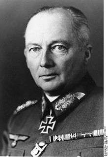 Black-and-white portrait of an older man wearing a military uniform with an Iron Cross displayed at his neck, his hair is combed back.