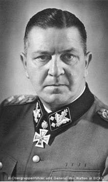 A man in semi profile wearing a military uniform and neck order, in the shape of a cross. His dark hair is combed to the back. He has determined facial expression.