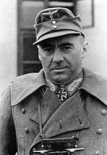 A black-and-white photograph of an older man wearing a military uniform, field cap and a neck order in shape of an Iron Cross.