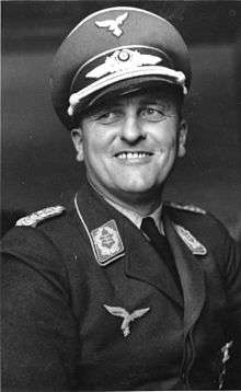 A black-and-white photograph of a smiling man in a military uniform.
