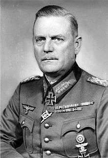 A black-and-white photograph of a man wearing a military uniform and a neck order in shape of an Iron Cross.