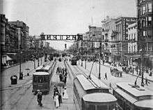 New Orleans in the 1900s. "Canal Street--The Broadway of New Orleans". Shows view looking riverwards from the 800 block, with electric streetcar, pedestrian, and carriage traffic. Signage for streetcars to West End over center of neutral ground.