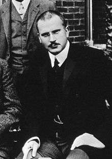A black and white image of Carl Jung, wearing formal clothing.