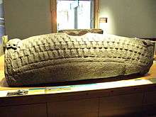 Photograph of a hogback sculpted tombstone