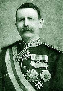 Moustached man in uniform emblazoned with medals