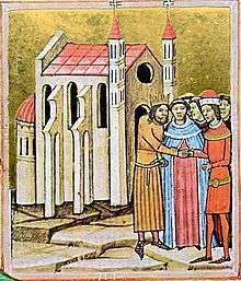 A crowned man and a man wearing a hat shake hands before a priest at a church