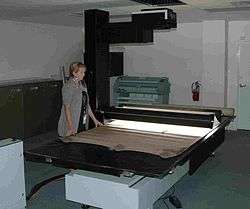 Lady standing at kitchen-table-sized scanner