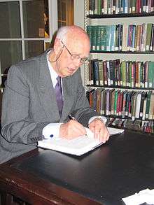 Photograph of Curtis Roosevelt signing a book at the Boston Athenæum in 2010