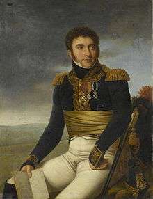 Painting of a sitting man in an early 1800s military uniform. He wears a dark blue coat with gold braid and epaulettes, white breeches and a wide scarlet sash wrapped around his waist.