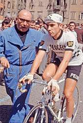 Eddy Merckx being pushed while on bike before a stage.