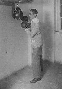 Deutsch posing with boxing gloves and a punching bag
