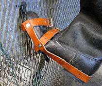 Close-up view of a boot which has been modified with a hooked overshoe, shown on a section of border fence to demonstrate how it would have been used to climb the fence.