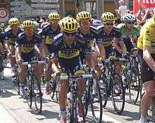 A group of cyclists wearing blue and yellow clothing.