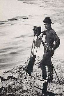Photographer and camera along river