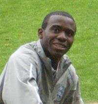 Young black man with close-cropped hair wearing a grey anorak