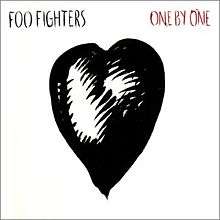 A black heart drawing against a white background. On the upper left is "Foo Fighters" in black letters, and on the upper right, "One by One" in red ones.