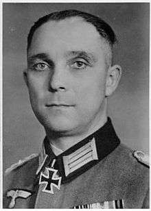 A black-and-white photograph of a man wearing a dark military uniform with a neck order in shape of an Iron Cross.