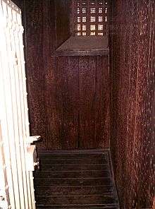 Cell with walls and floor covered in Jarrah, held with an abundance of nails