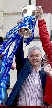 Gary Mills holding aloft a trophy