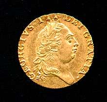 Gold coin bearing the profile of a round-headed George wearing a classical Roman-style haircut and laurel-wreath.