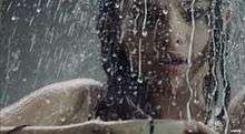 A portrait of a young brunette woman taking a shower.