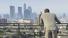 The player character with their back to the camera, and the sprawl of an urban city centre in front of them.